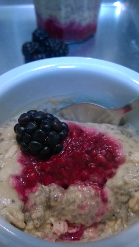 custard cup filled with peanut butter chia and plant milks topped with berry compote 
