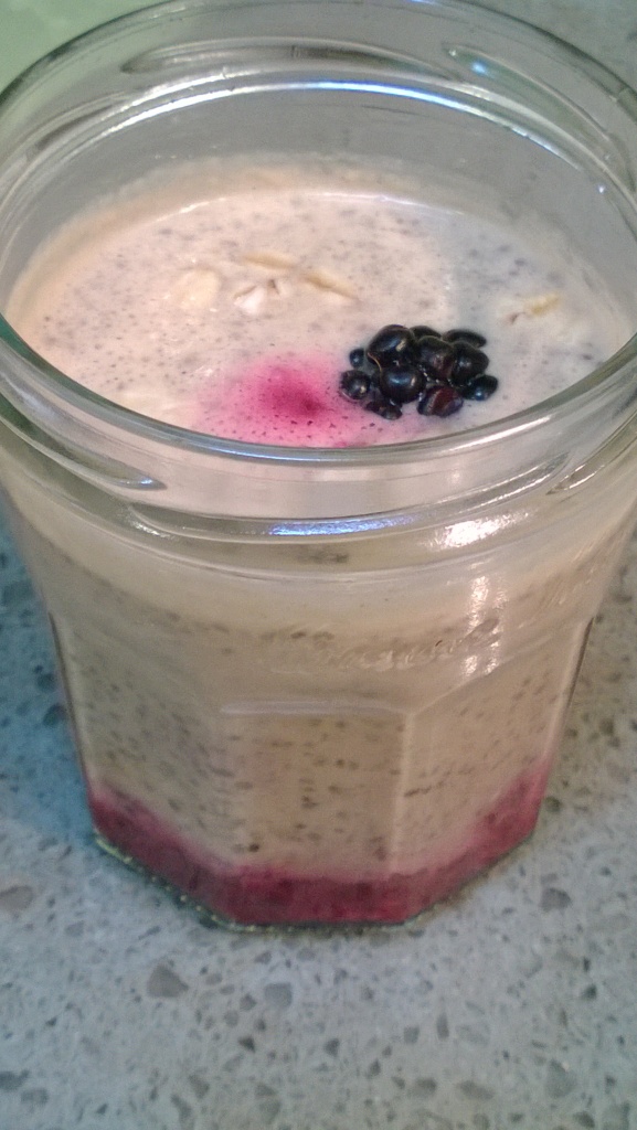 peanut butter and berry chia cup topped with a blackberry